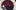A man with a painted face and wearing a red jester's outfit with bells on the hat, alongside the text: A spy life peering