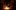 Two actors sit on the stage of the Sam Wanamaker Playhouse with fairy lights above them