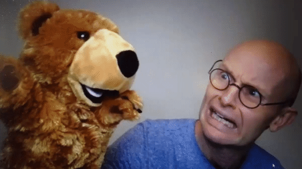 An animation of a teddy bear attacking a man, with a flag reading: Exit, pursued by a bear