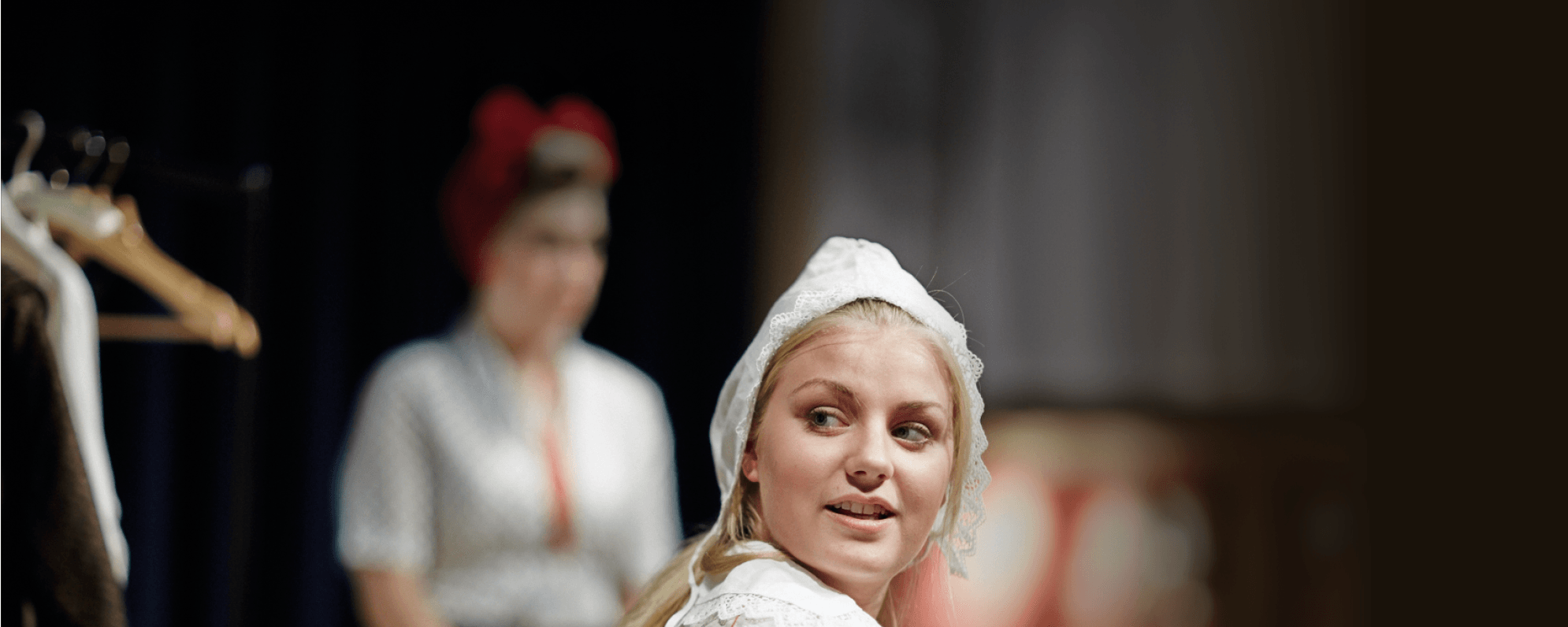 A woman wearing an Elizabethan headpiece and dress.