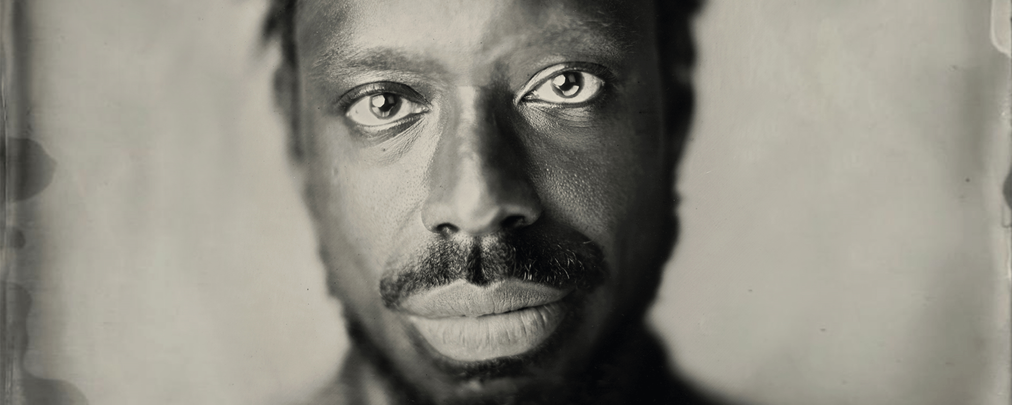 An image of a man in black and white staring forward