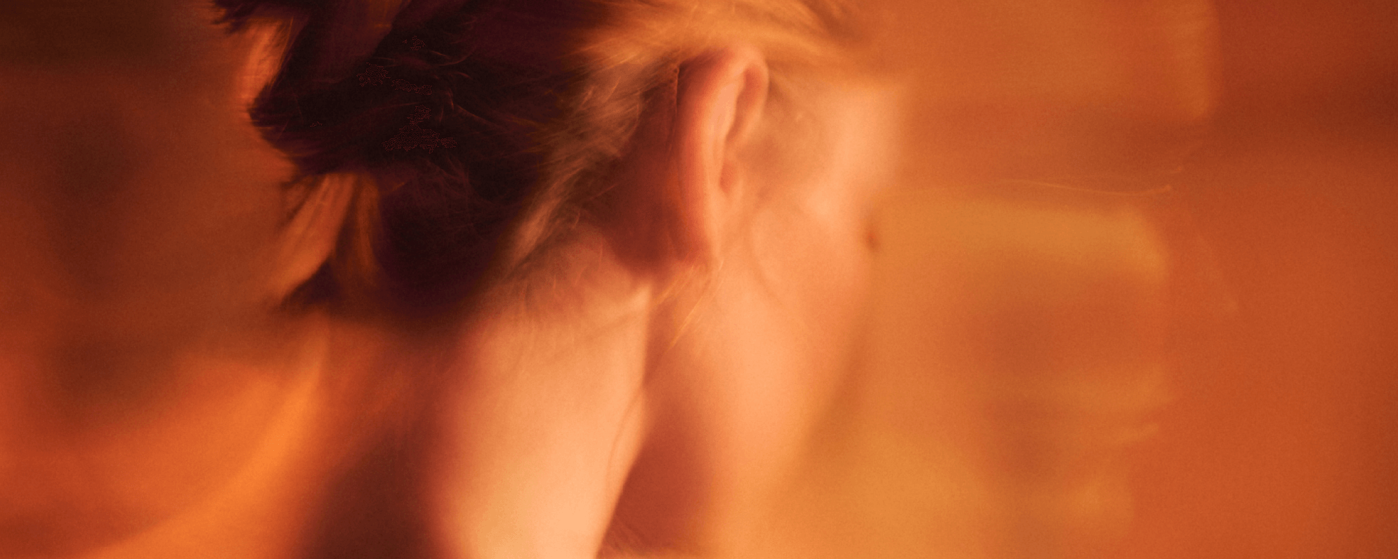 An actor facing away from camera, blurred silhouettes of two other actors are superimposed in the background