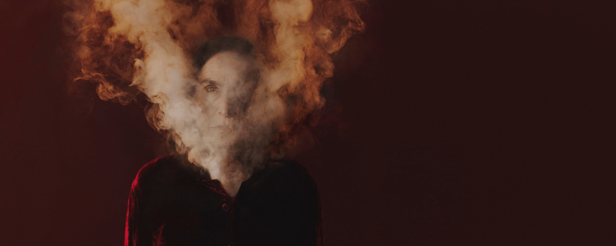 A cloud of smoke rising from an actor's clothes, obscuring their face