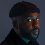 Headshot of Ken Nwosu wearing a black cap and looking at the camera.