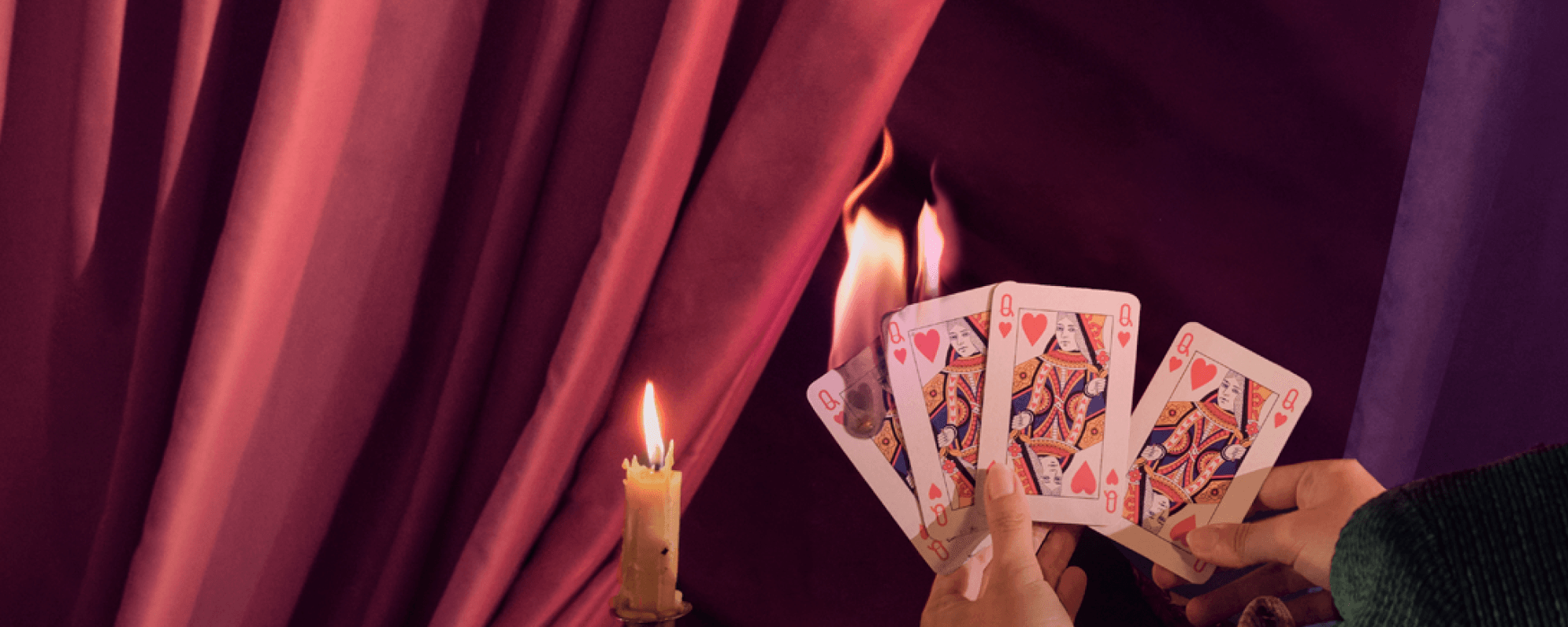 Photo of four playing cards, all Queen of Hearts, on fire.