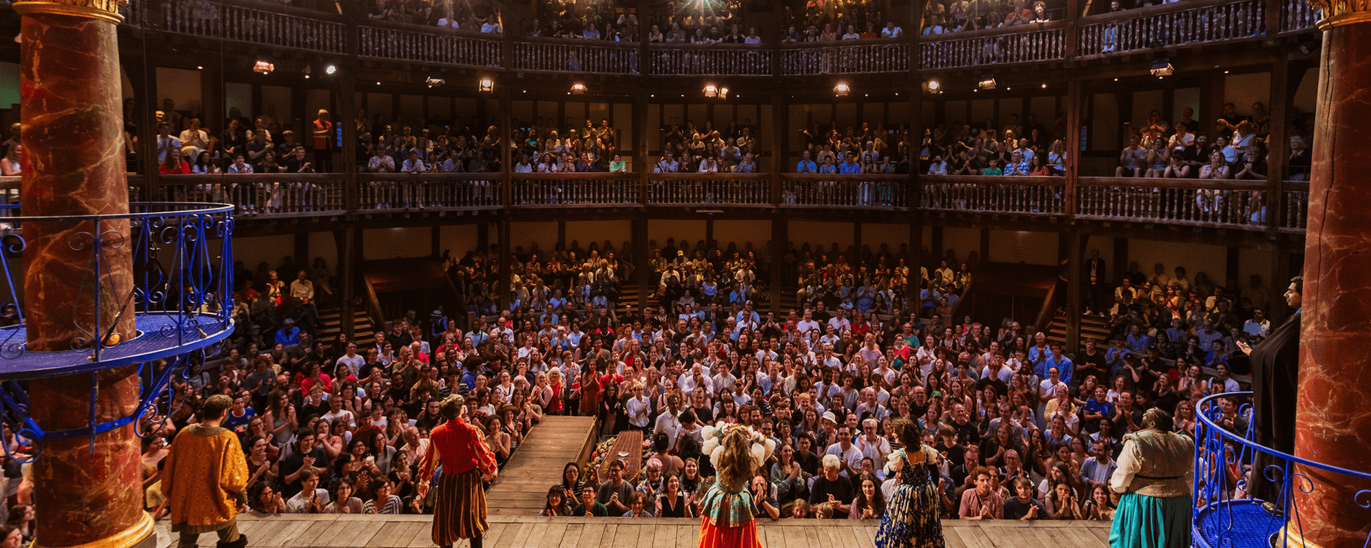 Image of people bowing onstage to a full house at the Globe