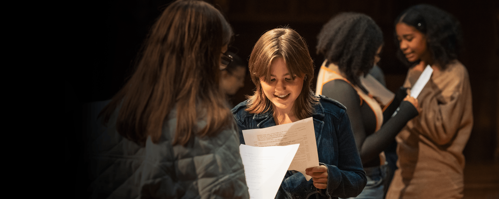 Teenagers reading scripts and smiling