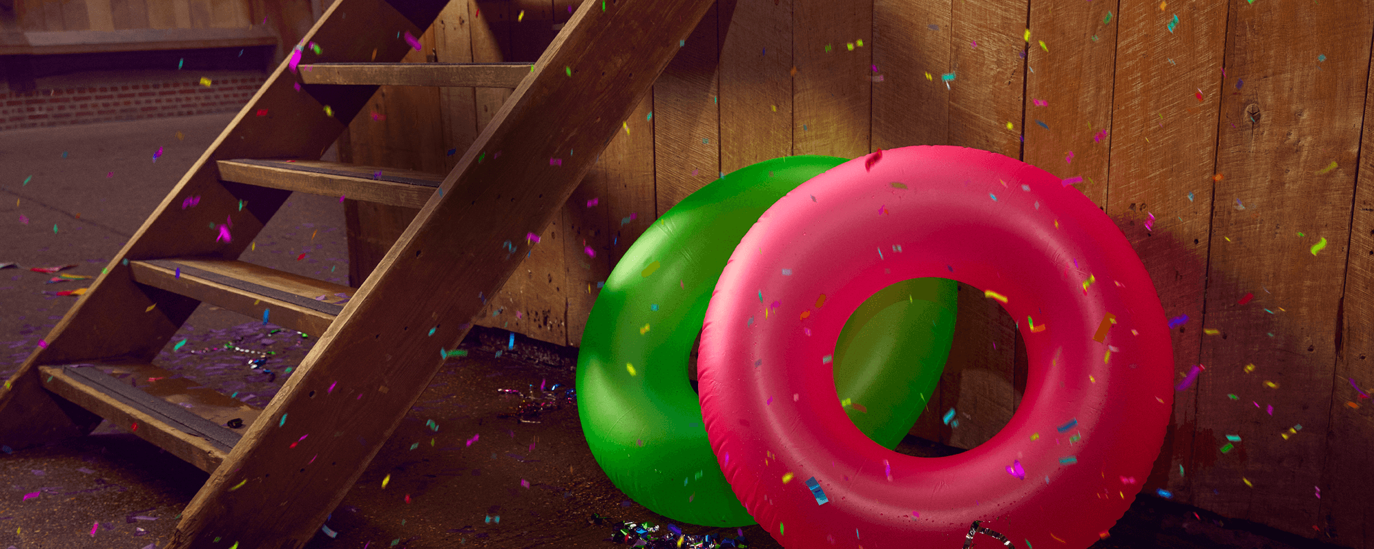 Two rubber rings (as if from a pool party) propped up by the Globe stage, surrounded by confetti