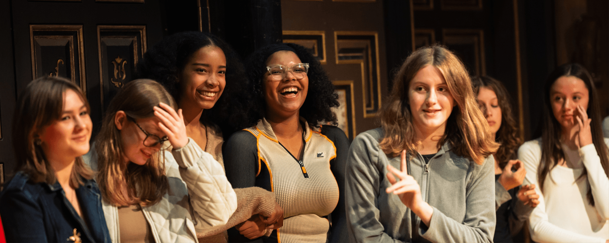 Young people laughing on stage in a workshop