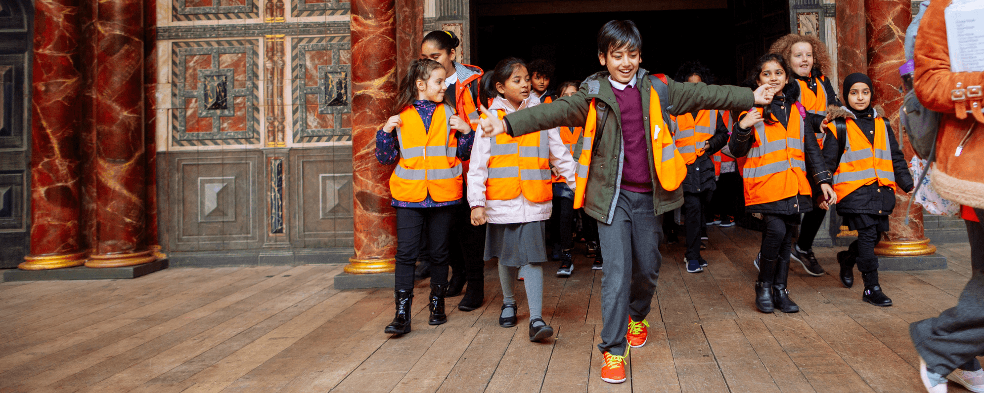 A group of primary school students in the Globe Theatre