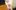 Actor and director Tim Crouch is in-between two blurred bodies in the foreground. He looks up at them.