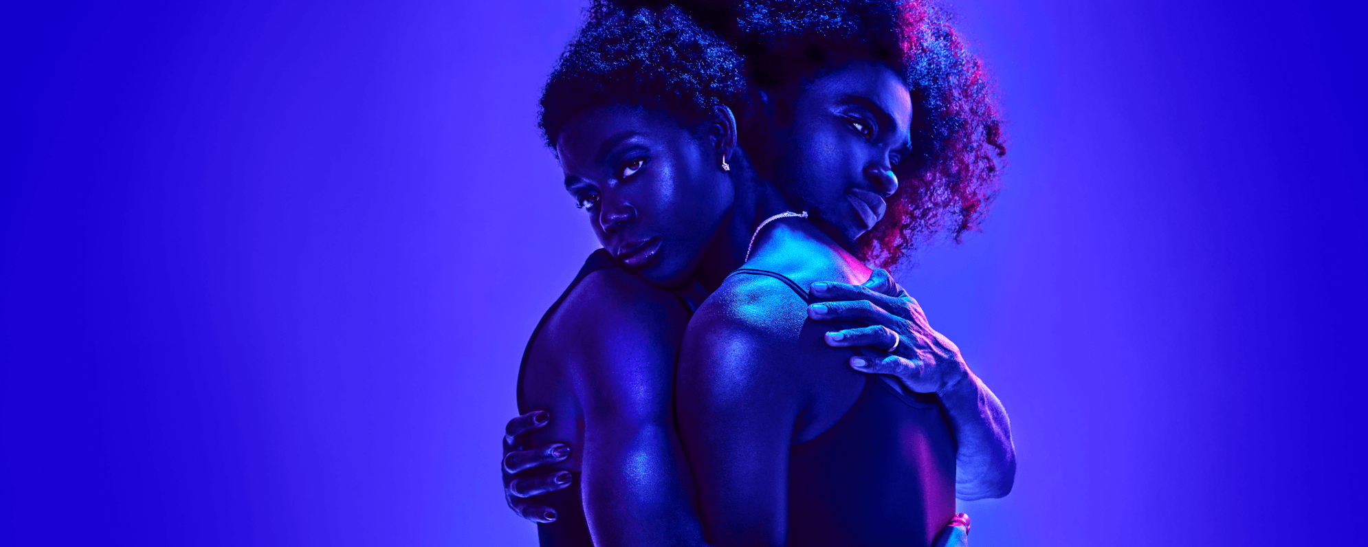 Two people embrace, Jayden Elijah as Deep and Selina Jones as Azure, bathed in purple light.