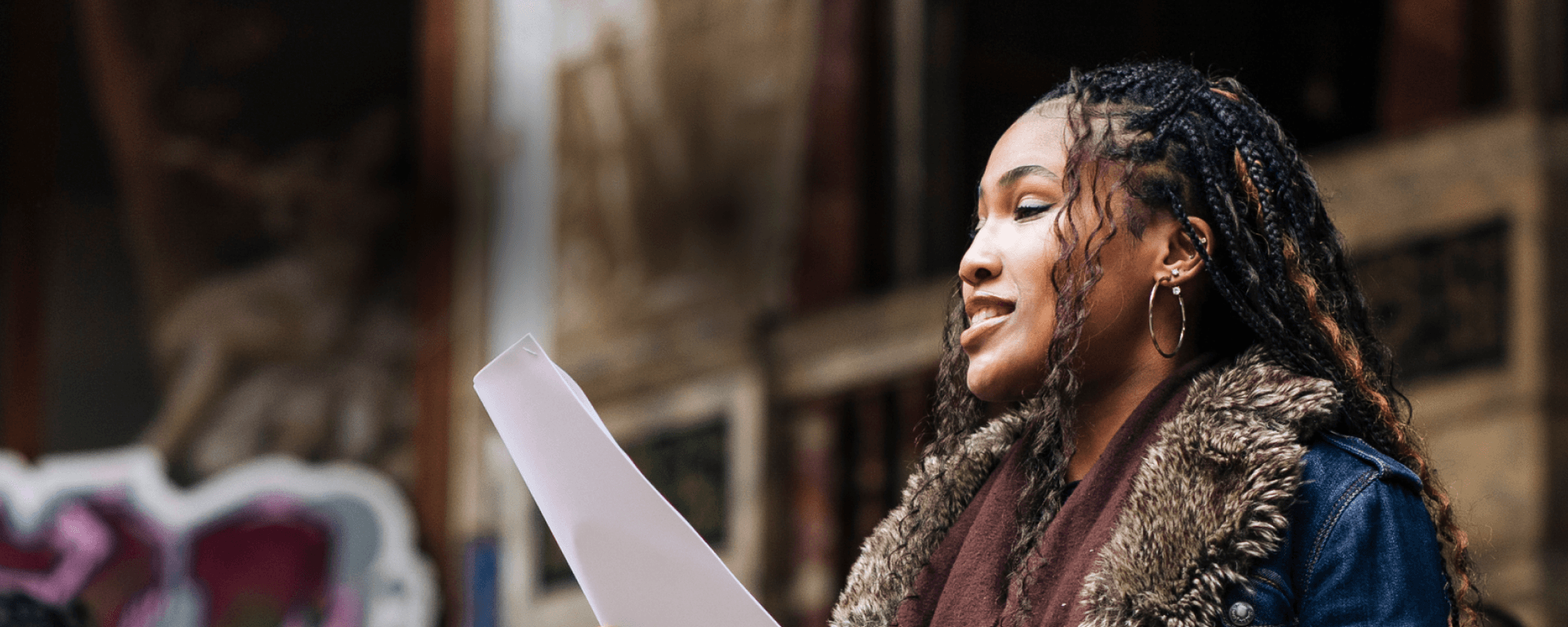 A person holding a piece of paper, smiling.