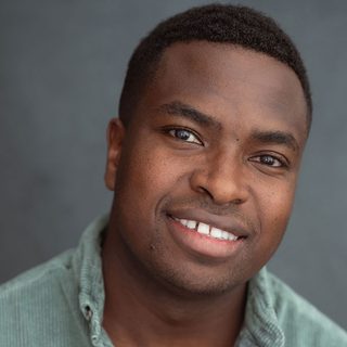 Headshot of Adrian Richards smiling at the camera.