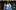 Three people stand together, holding hands. One is a mixed race non-binary person with short Afro/curly hair, one is a mixed-race white and Caribbean woman, also with Afro/curly hair, one is white Caucasian with blonde hair.