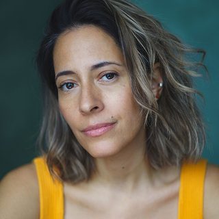 Headshot of Jimena Larraguivel, wearing a yellow top and looking directly at the camera.