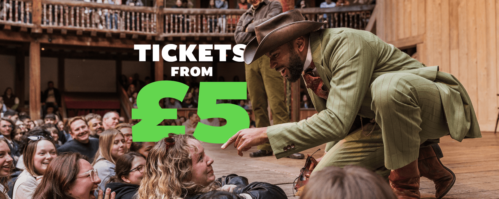 Tickets from £5. An actor onstage interacts with audience members in the Yard. Everyone is smiling and laughing.