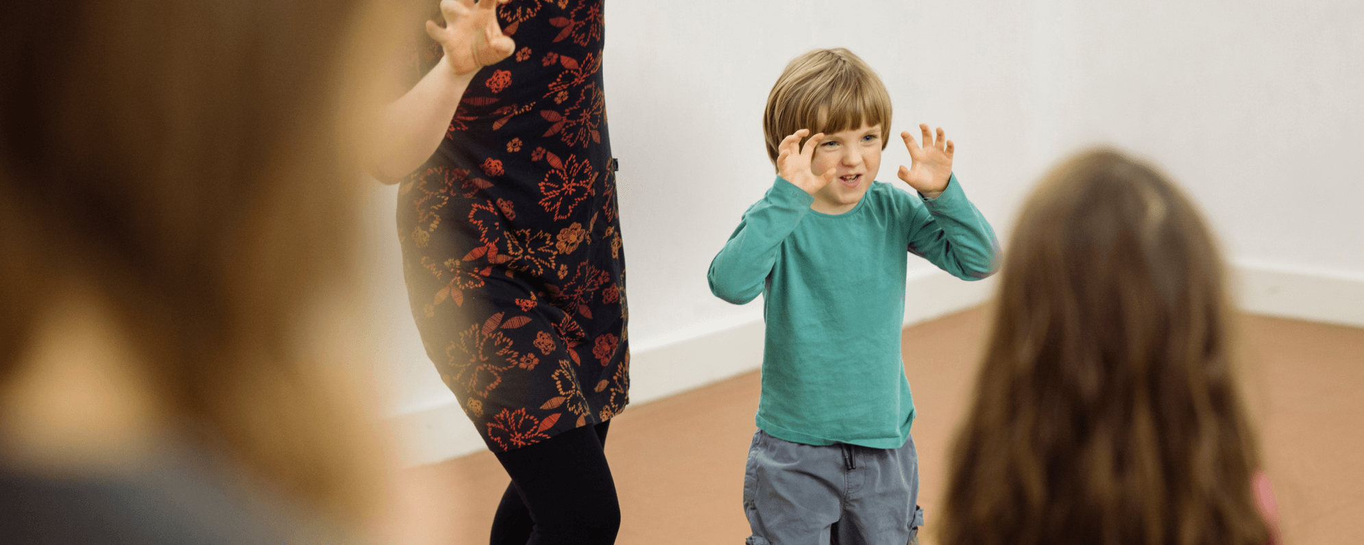 A child holding their hands up as they take part in a workshop.