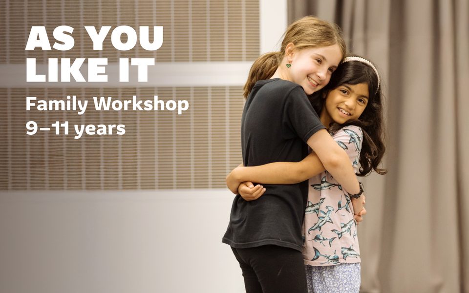 As You Like It Family Workshop. 9-11 years. Two children stand in a room, hugging and smiling.