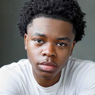 Headshot of Kyle Ndukuba wearing a white t-shirt and looking directly at the camera.