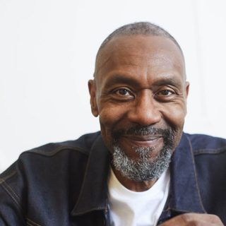 Headshot of Lenny Henry smiling at the camera.