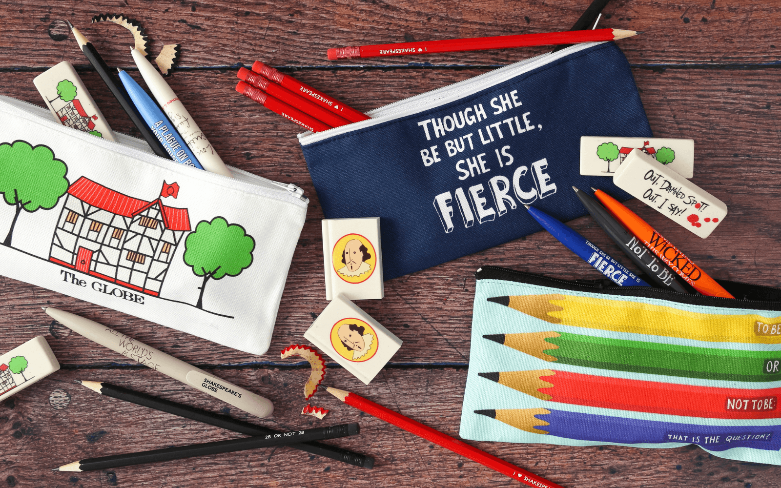 Pencil-cases, pens and pencils on a wooden table.