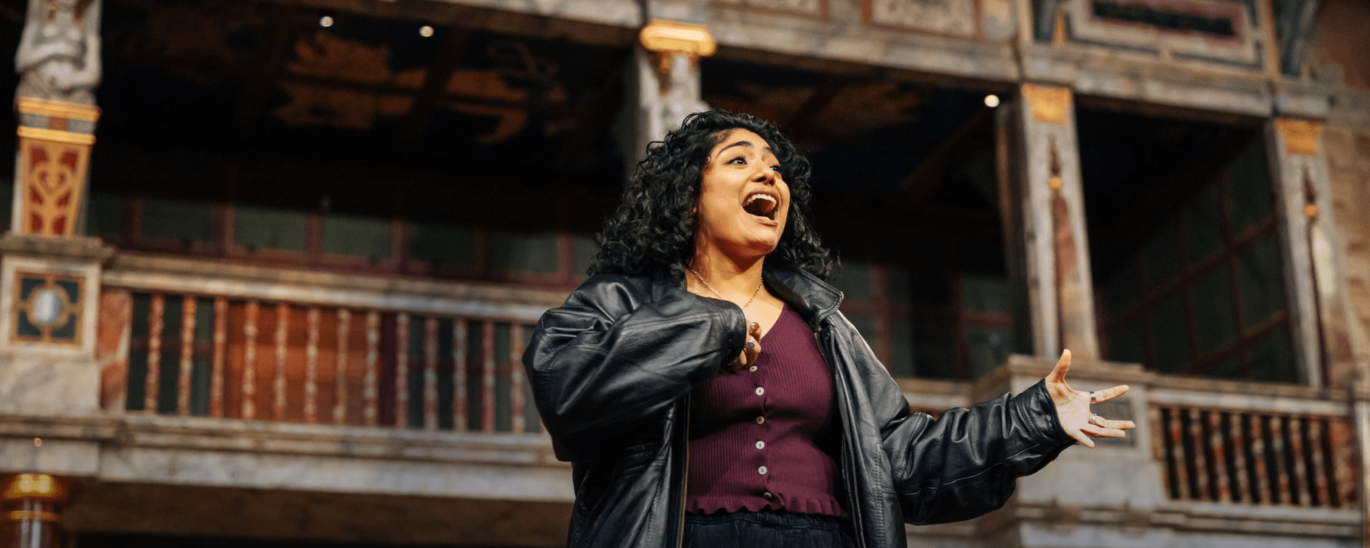Person in leather jacket on the Globe stage